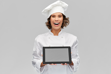 Image showing smiling female chef in toque with tablet computer