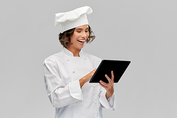 Image showing smiling female chef in toque with tablet computer