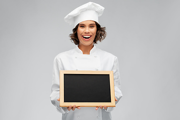 Image showing smiling female chef holding black chalkboard