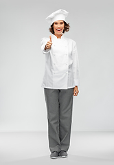 Image showing smiling female chef in toque showing thumbs up