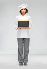 Image showing female chef holding black chalkboard