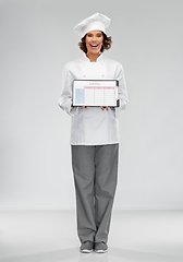 Image showing smiling female chef holding with diet plan
