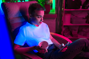 Image showing Cinematic portrait of handsome young woman in neon lighted interior