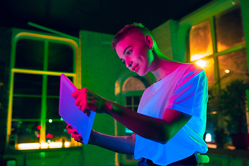 Image showing Cinematic portrait of handsome young woman in neon lighted interior