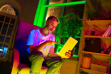 Image showing Cinematic portrait of handsome young woman in neon lighted interior