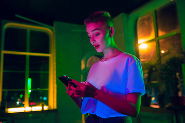 Image showing Cinematic portrait of handsome young woman in neon lighted interior