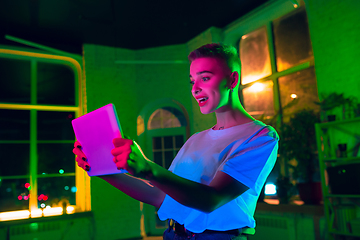 Image showing Cinematic portrait of handsome young woman in neon lighted interior