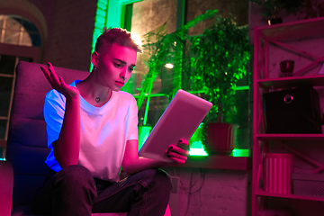 Image showing Cinematic portrait of handsome young woman in neon lighted interior