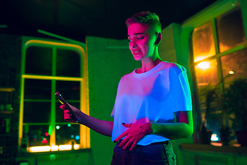 Image showing Cinematic portrait of handsome young woman in neon lighted interior