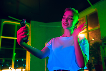 Image showing Cinematic portrait of handsome young woman in neon lighted interior