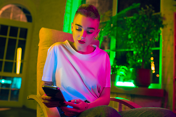 Image showing Cinematic portrait of handsome young woman in neon lighted interior