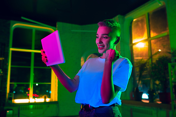 Image showing Cinematic portrait of handsome young woman in neon lighted interior