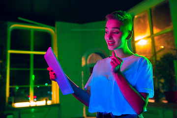 Image showing Cinematic portrait of handsome young woman in neon lighted interior