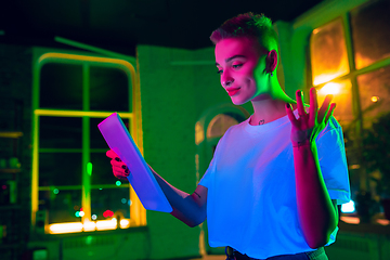 Image showing Cinematic portrait of handsome young woman in neon lighted interior