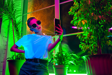 Image showing Cinematic portrait of handsome young woman in neon lighted interior