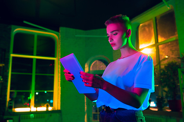 Image showing Cinematic portrait of handsome young woman in neon lighted interior