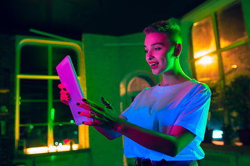 Image showing Cinematic portrait of handsome young woman in neon lighted interior