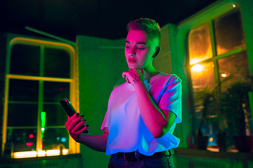 Image showing Cinematic portrait of handsome young woman in neon lighted interior