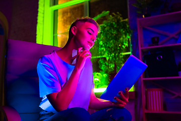 Image showing Cinematic portrait of handsome young woman in neon lighted interior