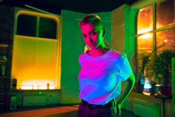 Image showing Cinematic portrait of handsome young woman in neon lighted interior