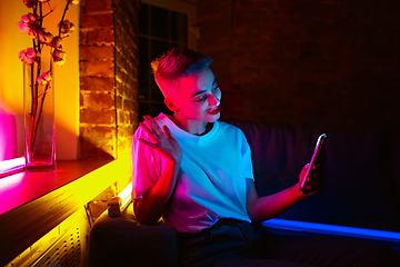 Image showing Cinematic portrait of handsome young woman in neon lighted interior