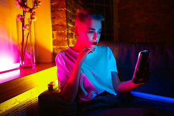 Image showing Cinematic portrait of handsome young woman in neon lighted interior