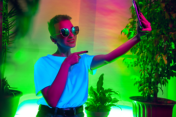 Image showing Cinematic portrait of handsome young woman in neon lighted interior