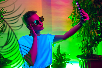 Image showing Cinematic portrait of handsome young woman in neon lighted interior