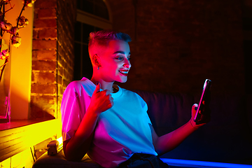 Image showing Cinematic portrait of handsome young woman in neon lighted interior