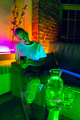 Image showing Cinematic portrait of handsome young woman in neon lighted interior