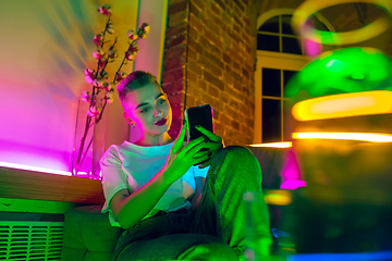 Image showing Cinematic portrait of handsome young woman in neon lighted interior