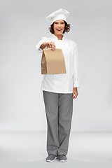 Image showing happy female chef with takeaway food in paper bag