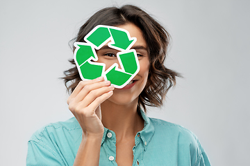 Image showing smiling woman looking through green recycling sign