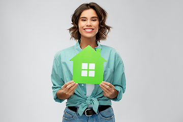 Image showing smiling young woman holding green house