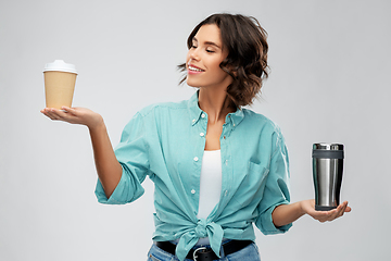 Image showing woman comparing thermo cup and paper coffee cup