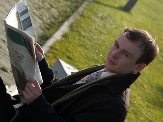 Image showing Young businessman reading newspaper