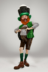 Image showing Excited leprechaun in green suit with red beard on white background