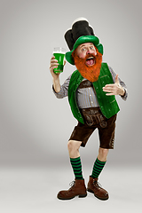 Image showing Excited leprechaun in green suit with red beard on white background