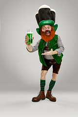 Image showing Excited leprechaun in green suit with red beard on white background