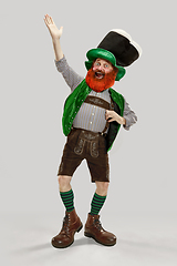 Image showing Excited leprechaun in green suit with red beard on white background