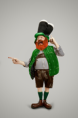 Image showing Excited leprechaun in green suit with red beard on white background