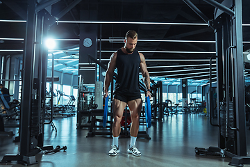 Image showing The male athlete training hard in the gym. Fitness and healthy life concept.