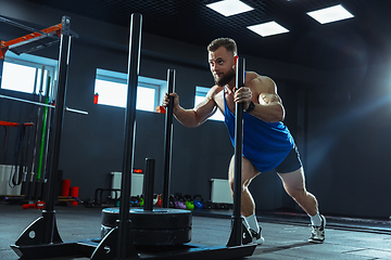 Image showing The male athlete training hard in the gym. Fitness and healthy life concept.