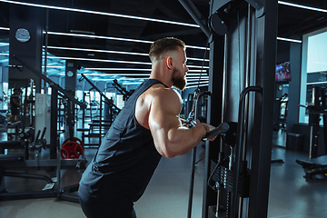 Image showing The male athlete training hard in the gym. Fitness and healthy life concept.