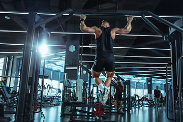 Image showing The male athlete training hard in the gym. Fitness and healthy life concept.