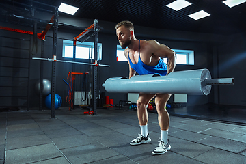 Image showing The male athlete training hard in the gym. Fitness and healthy life concept.