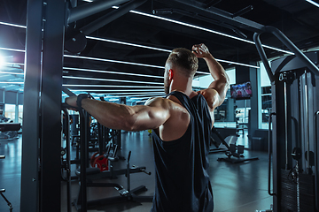 Image showing The male athlete training hard in the gym. Fitness and healthy life concept.