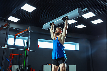 Image showing The male athlete training hard in the gym. Fitness and healthy life concept.