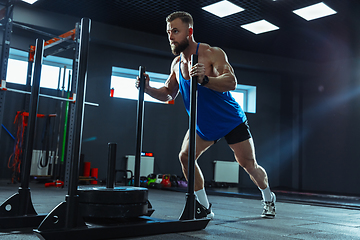 Image showing The male athlete training hard in the gym. Fitness and healthy life concept.