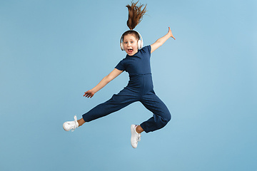 Image showing Pretty caucasian girl portrait isolated on blue studio background with copyspace